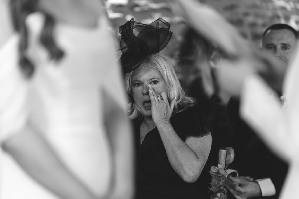 Mother of the bride crying during the ceremony candid moment captured by a documentary wedding photographer